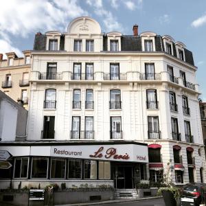 沙泰勒吉永巴黎酒店的一座高大的白色建筑,前面有一间餐厅