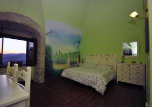 BovinoResidenza Bove Incoronato的卧室配有一张床,墙上挂有绘画作品
