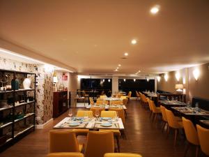 波多诺伏Hotel Boutique Aquaria Caneliñas的用餐室配有桌子和黄色椅子