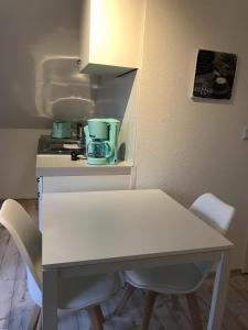 奈斯玛兹埃勒Kleine Möwe的厨房里配有白色的桌椅
