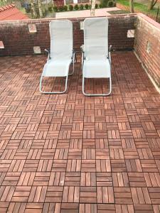 奈斯玛兹埃勒Kleine Möwe的砖砌庭院里两把白色椅子