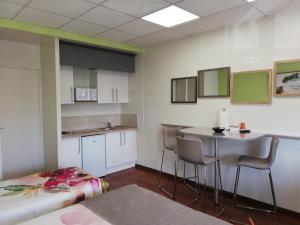 波旁朗西埃塔普杜拉克公寓式酒店的客房设有厨房、桌子和椅子。