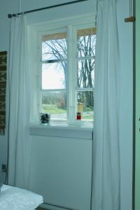 Thurø ByGrastenhus Guesthouse的卧室的窗户,带白色窗帘