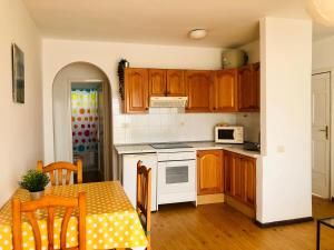 蒂亚斯Apartamento Lisa的厨房配有木制橱柜和带微波炉的桌子。