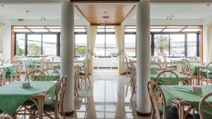 皮里亚波利斯里卡迪酒店的用餐室配有绿色的桌椅