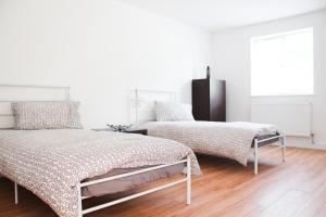 班戈卢克斯公寓的白色客房的两张床,铺有木地板