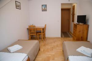 克拉科夫圣西蒙大教堂民宿的带两张床和一张桌子的房间以及一间用餐室