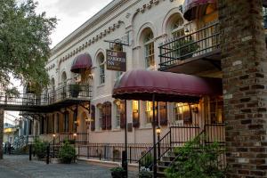 萨凡纳Olde Harbour Inn, Historic Inns of Savannah Collection的前面有伞的建筑