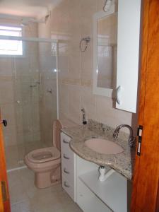 乌巴图巴Condomínio Pedra Coral的浴室配有卫生间、盥洗盆和淋浴。