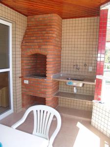 乌巴图巴Condomínio Pedra Coral的前面有白色椅子的砖炉