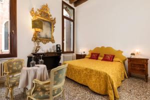 威尼斯Luxury Venetian Rooms的卧室配有一张床和一张桌子及椅子