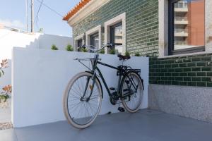 贡多马尔Green Villas Douro的停在建筑物旁边的墙上的自行车