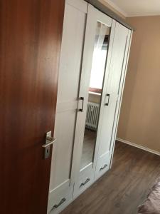 萨尔布吕肯Central-Apartment-Adria的门旁带镜子的白色橱柜