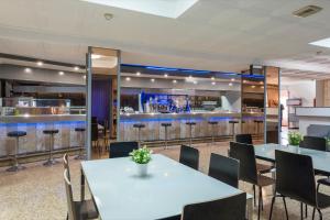 卡里拉Hotel Mar i Sol的一间带桌子的用餐室和一间酒吧