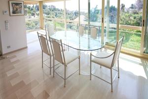 戛纳Appartement Luxueux 150m2 - Cannes的一间设有玻璃桌和椅子的用餐室
