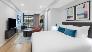 阿德莱德Avani Adelaide Residences的一间卧室设有一张床和一间客厅。