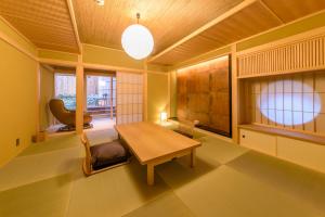 京都花筏日式旅馆的客厅配有木桌和椅子