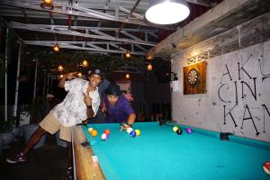 巴东Kokos Hostel Padang City的两人在台球桌打台球