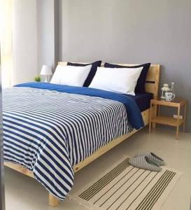 梅尔皮姆Grandblue 411的一间卧室配有一张带蓝白条纹毯子的床