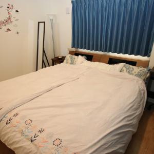 北谷町Alaha Blue Resort 6F -SEVEN Hotels and Resorts-的一张带白色棉被和蓝色窗帘的床