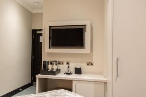 伦敦The Crescent Hyde Park的卧室设有壁挂式电视和桌子。