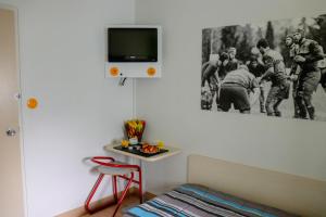 勒帕萨吉Hoteleco Sud Agen Autoroute的卧室设有壁挂式电视和桌子。