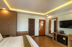曼谷Stable Lodge - SHA Certified的配有一张床和一台平面电视的酒店客房