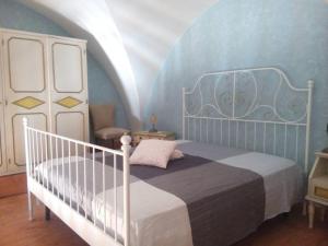 焦维纳佐Secret Garden的卧室配有白色的床和蓝色的墙壁