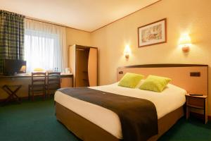 什切青坎普尼尔什切青酒店的酒店客房配有一张带黄色枕头的大床