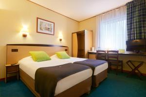 什切青坎普尼尔什切青酒店的酒店客房设有一张大床和一张书桌。