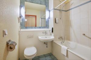 什切青坎普尼尔什切青酒店的浴室配有盥洗盆、卫生间和浴缸。
