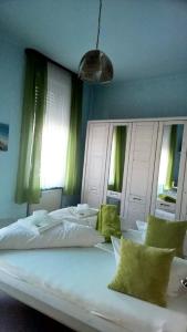 吕德斯海姆索马山酒店的卧室里一张大白色的床,配有绿色窗帘