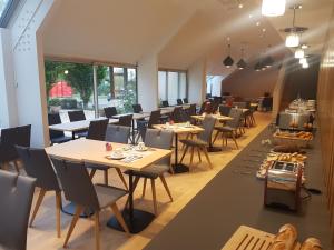 迪南Best Western Armor Park Dinan的用餐室设有桌椅和窗户。
