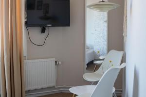 阿灵厄桑维哈弗酒店的一间设有两把椅子和一台墙上的电视的房间
