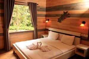 普卡Safari Resort的一间卧室,床上配有2条天鹅毛巾