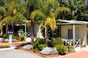 珀斯阿卡莱姆锦斯维观光园酒店的前面有棕榈树的房子