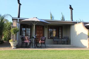 温特顿Drakensview Self Catering的房屋配有桌椅和遮阳伞