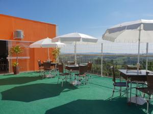 伊图佩瓦Hotel ITR-SPA的一个带桌椅和遮阳伞的庭院