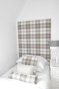 爱丁堡国际宾馆的一张带拼盘床头板和白色枕头的床