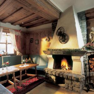 瑟弗浩斯Hotel Garni Serfauserhof的客厅设有壁炉、桌子和桌子