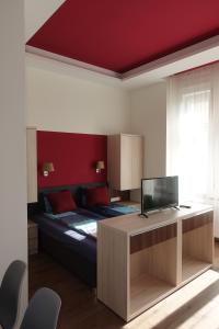 布达佩斯Frank & Fang Apartments MK7的一间卧室配有一张床和一张书桌及电视