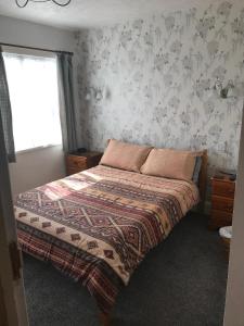 佩恩顿Jacaranda Hotel的一间卧室配有一张带毯子的床和窗户