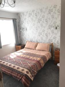 佩恩顿Jacaranda Hotel的一间卧室配有一张床铺,床上有毯子