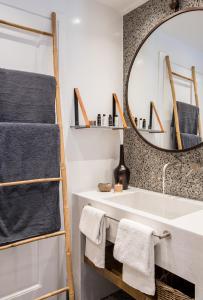 费拉Amelot Art Suites的一间带大镜子和盥洗盆的浴室