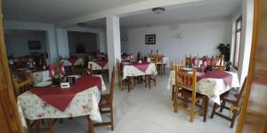 卡斯特罗波尔Hostal Restaurante Parajes的餐厅设有桌椅,配有红色和白色的桌布