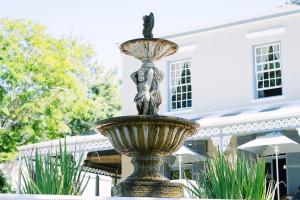 帕尔彭坦克庄园酒店&餐厅的一座建筑物前喷泉中的女人雕像