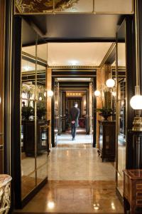 巴黎La Réserve Paris Hotel & Spa的把雨伞从走廊上走的人