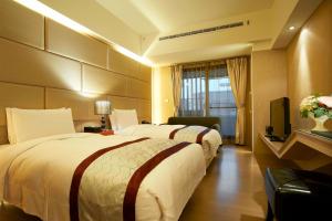 台北大师商旅的酒店客房设有两张床和电视。