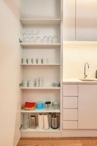 里斯本Ouro Grand by Level Residences的厨房配有白色橱柜和水槽