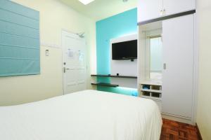 马六甲The One Vacation Home的卧室配有白色的床和平面电视。